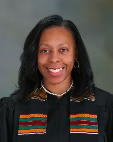 Photo of a woman with shoulder-length black hair wearing a black judge gown