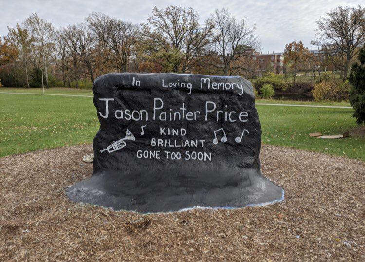 the rock at MSU painted black with white writing 