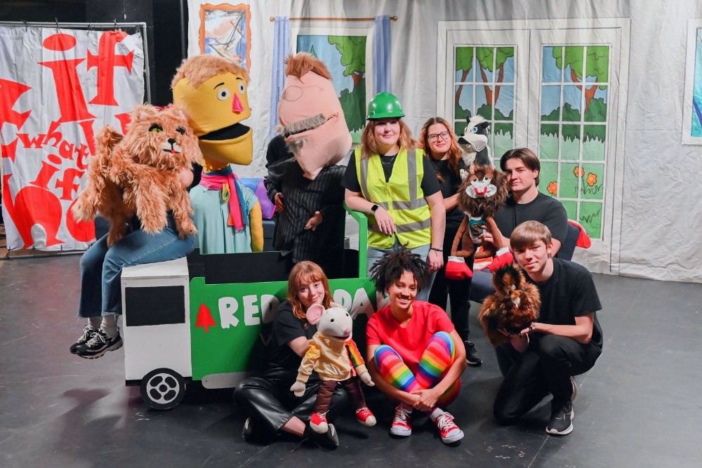 The full "What If Wilhelmina" cast in their costumes with their puppets on the set 