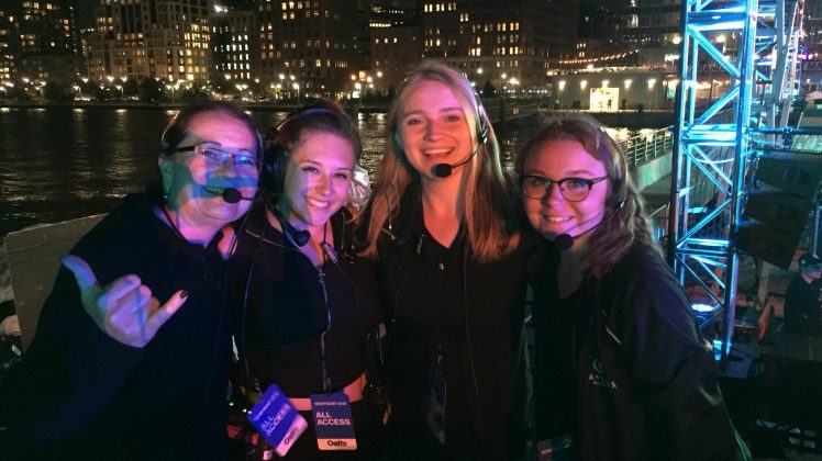 Students wearing headsets outside at night with a city in the background
